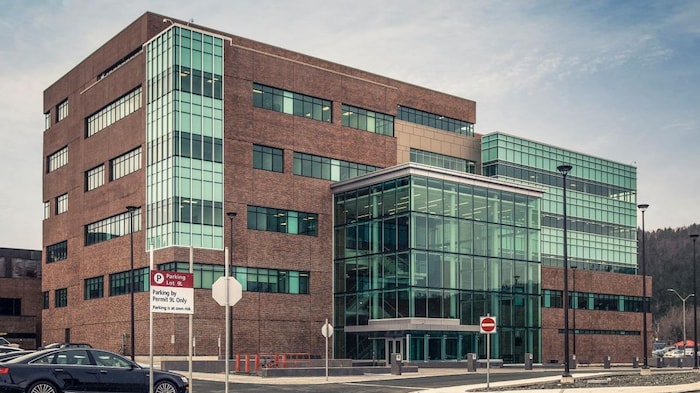 Une photo professionnelle d'un bâtiment bien brun avec des sections vitrées.