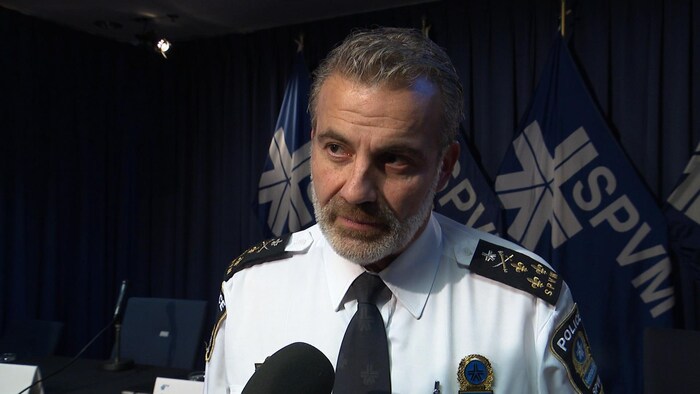 Fady Dagher en entrevue devant des logos du SPVM.