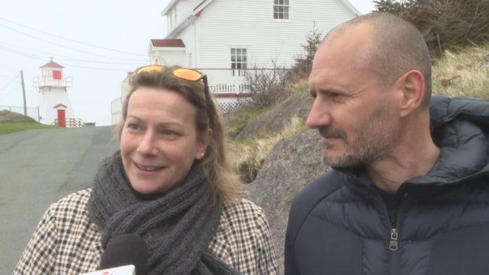 Un couple interviewé près d'un phare.