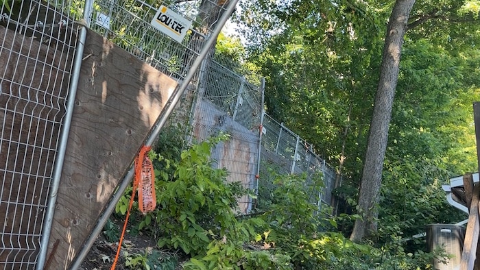 Une clôture de métal est installée sur le flanc d'une falaise.