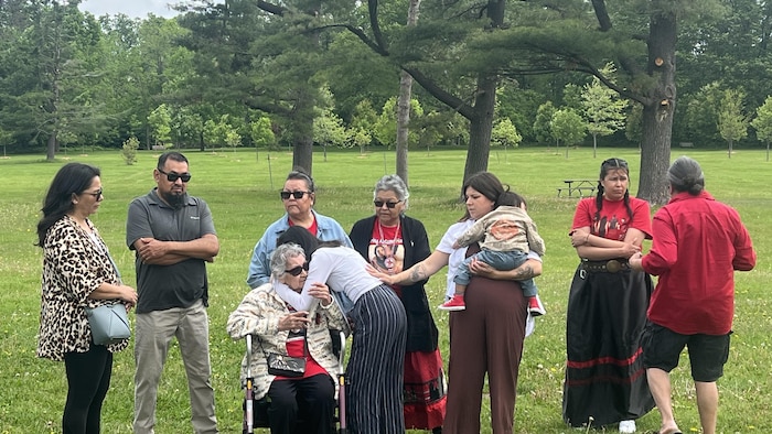 Dix personnes dans un parc, émues.