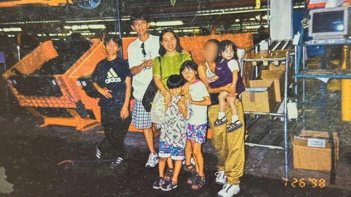 Joseph Jacildo et d’autres membres de sa famille devant des machines à l’usine d’assemblage.