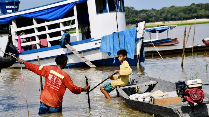 Une famille habite sur ce bateau, ancré sur la rive du lac Batata.