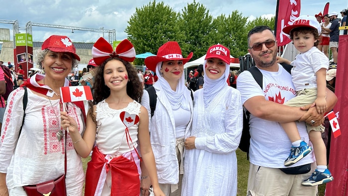 A Canadian family dressed in red and white at Canada Day. canada day marked "canadian pride"