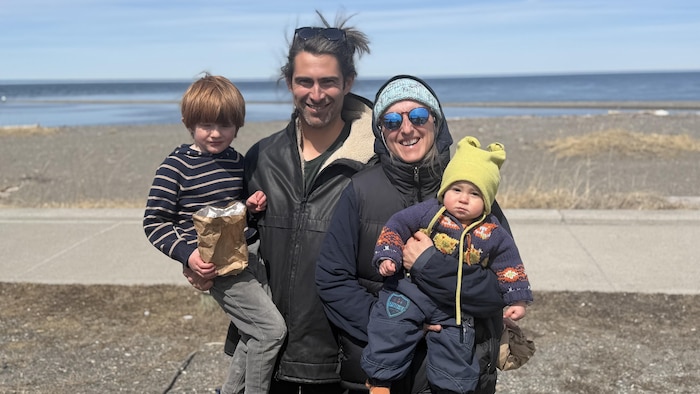 Charles Montbrillant-Leduc et Laurence Dufour devant le fleuve. Ils tiennent des enfants dans leurs bras.