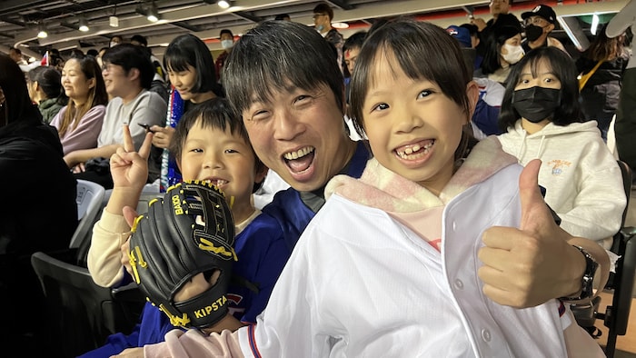 Chen Jian-Zhang qui lève un pouce, avec ses enfants dans les estrades du Taipei Dome.