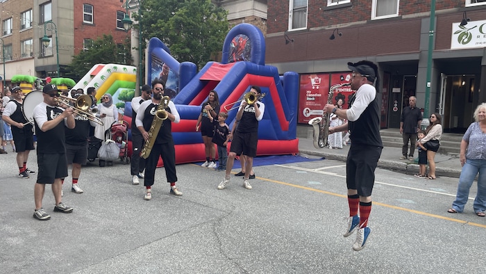Une fanfare joue de la musique dans la rue.