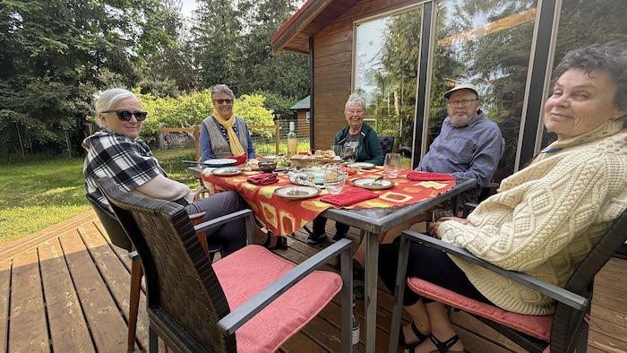 Cinq des six membres du Fanny Bay Groundwater Collective autour d'une table à l'extérieur.
