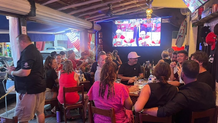 Des partisans québécois sont assis aux tables du resto-bar.