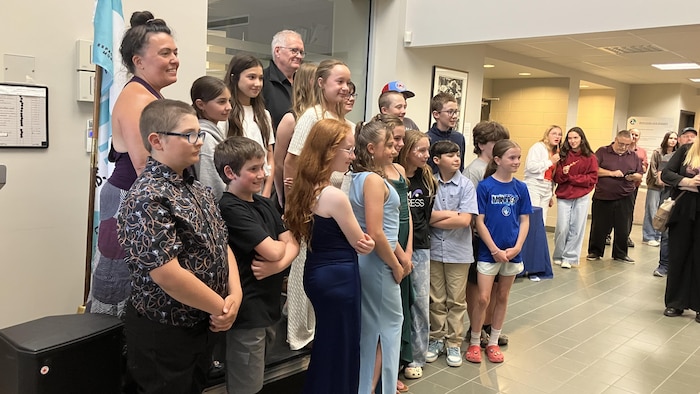 Plusieurs élèves accompagnés d'adultes posent pour la photo.