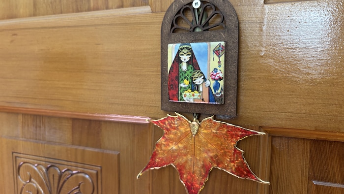 Une œuvre d'art dans laquelle on peut voir une miniature persane et une feuille d'étable orange.