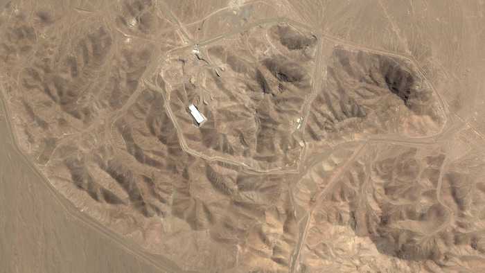 Image satellite montrant un petit bâtiment dans une zone montagneuse.
