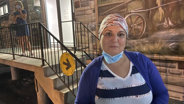 Une femme devant un escalier.