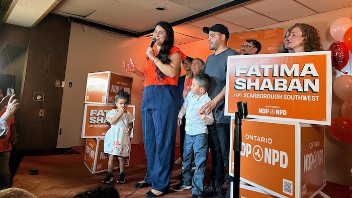 Fatima Shaban sur une scène en compagnie de sa famille, des membres de son équipe et de Marit Stiles.