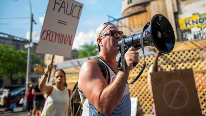 Fauci says the virus has been too politicized in the U.S., and he would know. He's become a political target himself, as seen at this protest at a pro-vaccination event he attended with Jill Biden in New York City on June 6.