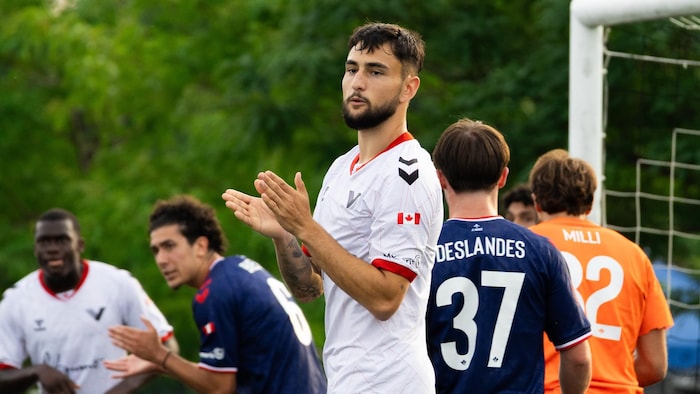 Des joueurs applaudissent sur le terrain après une occasion de marquer.