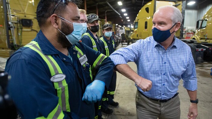 Conservative Party Leader Erin O’Toole greets employees at a trucking company while campaigning in Winnipeg, Friday, Aug. 20, 2021. O'Toole says Trudeau is dividing Canadians by politicizing the COVID-19 vaccine. 
