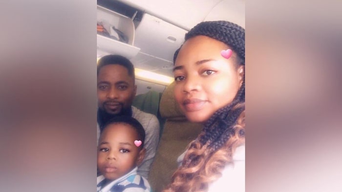 Selfie of a couple and their child sitting on a plane.