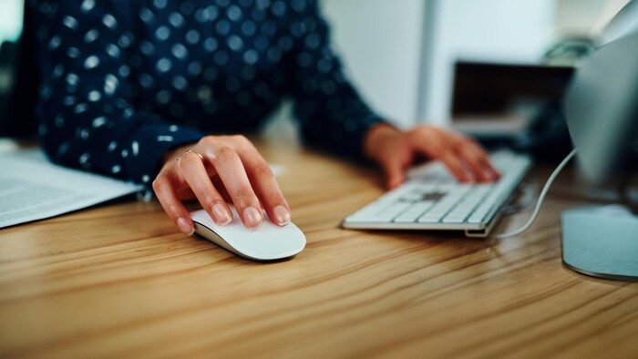 Gros plan d'une femme travaillant sur un ordinateur dans un bureau.