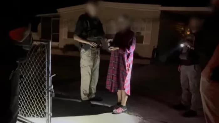 Une femme lors d'une arrestation la nuit.
