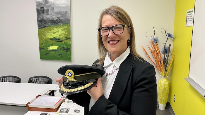 Rachelle Caron avec un chapeau de la Sûreté du Québec entre les mains.