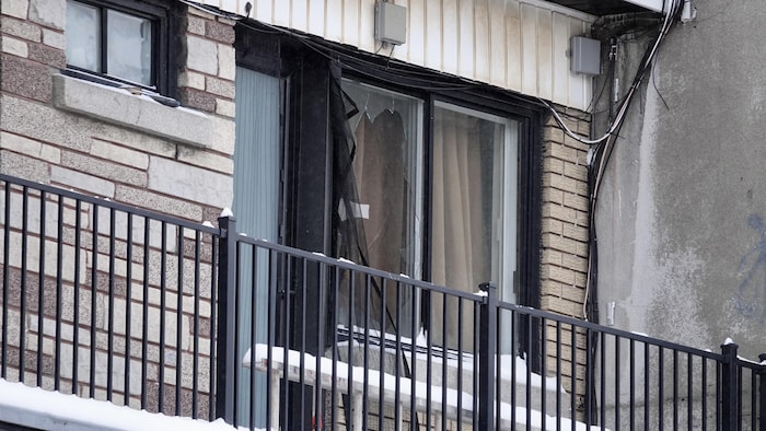 La fenêtre fracassée sur un balcon.