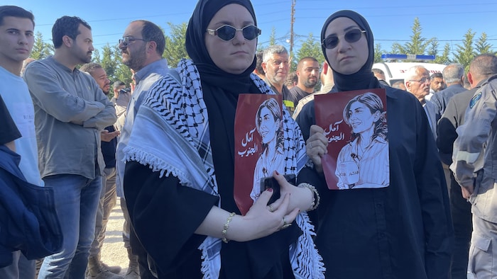 Reina Hoblos et Sabrina Ibrahim portant une affiche représentant le portrait d'Amal Khalil.