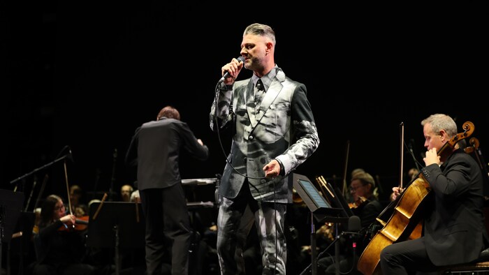 Pierre Lapointe accompagné d'un orchestre sur scène.