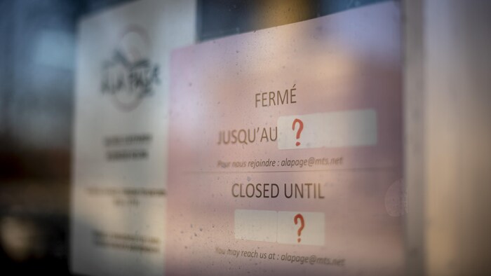 Une affiche où il est écrit qu'un magasin sera fermé pour une durée indéterminée. 