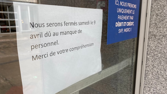 Une affiche sur une porte qui indique : « Nous serons fermés le 9 avril dû au manque de personnel ».