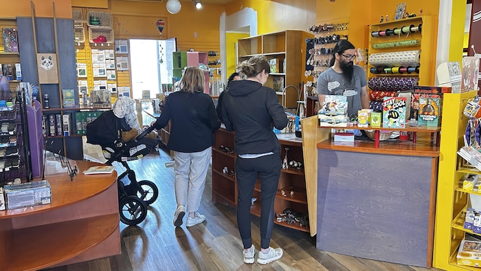 Deux clientes du magasin Roudoudou paient leurs achats à la caisse.