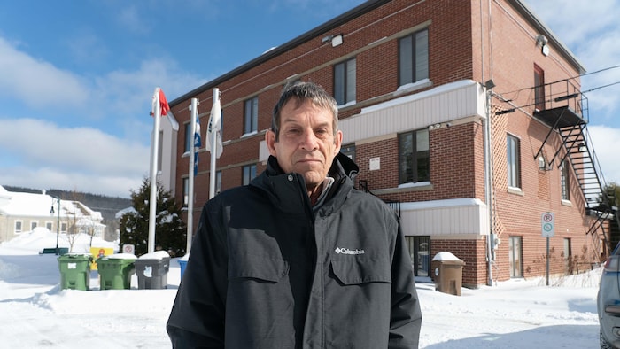 Le maire de Sayabec Lorenzo Ouellet devant l'école de sa municipalité. 