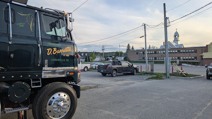 Un camion antique est stationné dans un grand stationnement.