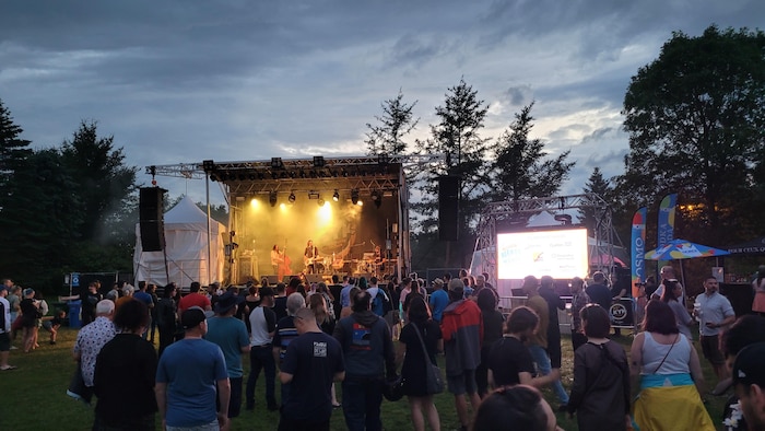 Un groupe de musique sur scène devant des spectateurs.