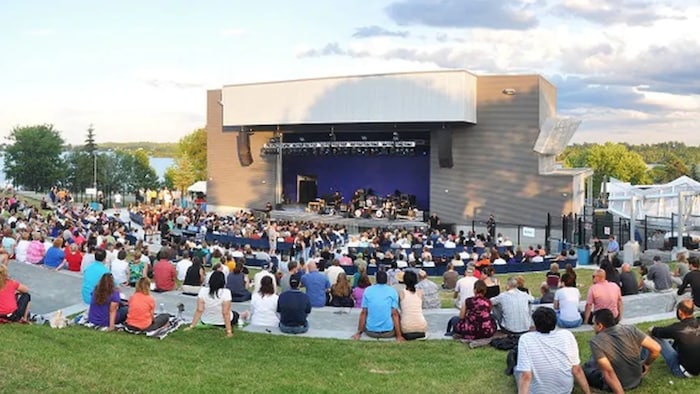 Des gens assis dehors écoutent un concert