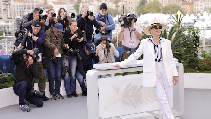 Meryl Streep pose entourée de photographes. 