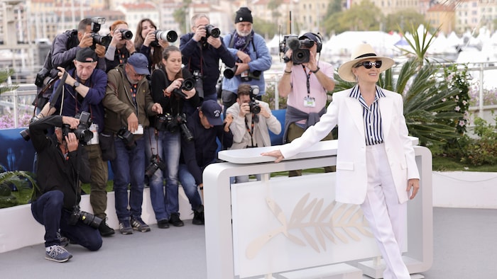 Meryl Streep poses surrounded by photographers. 