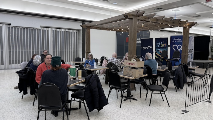 Des gens discutent autour des tables du café.
