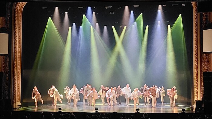 Une trentaine de danseurs sur une scène.