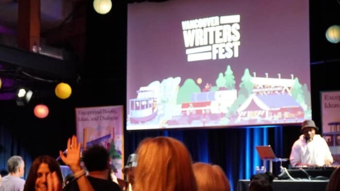 Un DJ joue devant une foule qui danse.