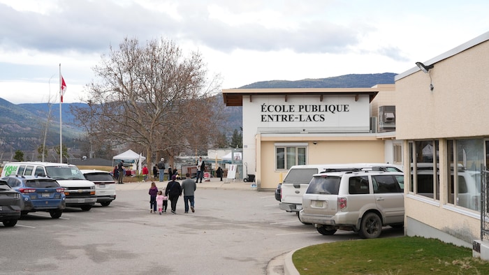 Une famille se dirige vers l’entrée de l’École Entre-Lacs à Penticton, le 7 mars 2026.