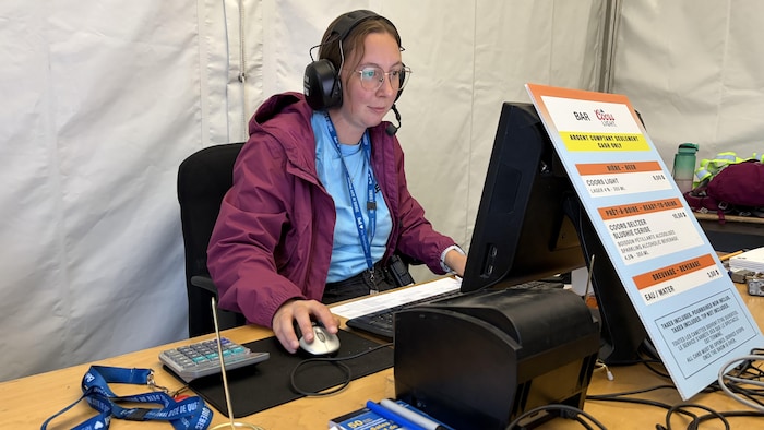 Une femme est assise à un bureau devant un ordinateur.