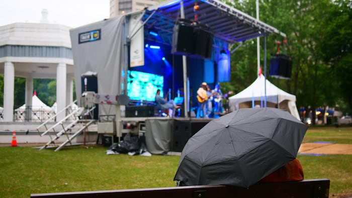 Une festivalière sous un parapluie pendant une prestation musicale du concert de clôture du Festval fransaskois.