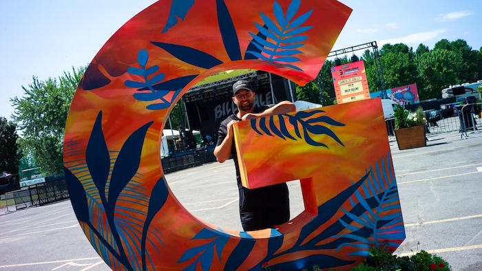 Mikaël St-Cyr devant une installation artistique de son festival. 