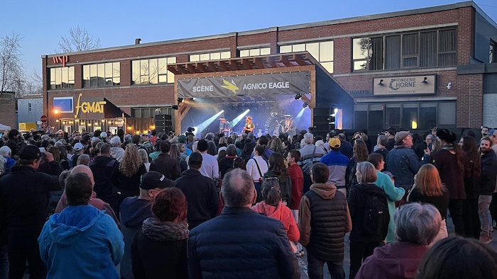 Des festivaliers regardent un spectacle de Bleu Jeans Bleu sur la scène extérieure du Festival des guitares du monde en Abitibi-Témiscamingue.