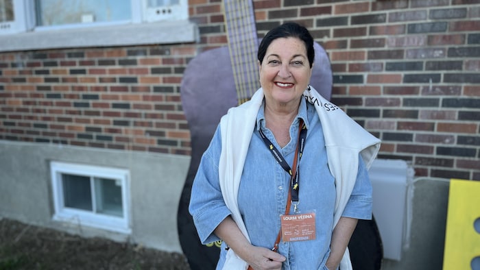 Louise Vézina pose devant une guitare géante, sur le site extérieur du Festival des guitares du monde.