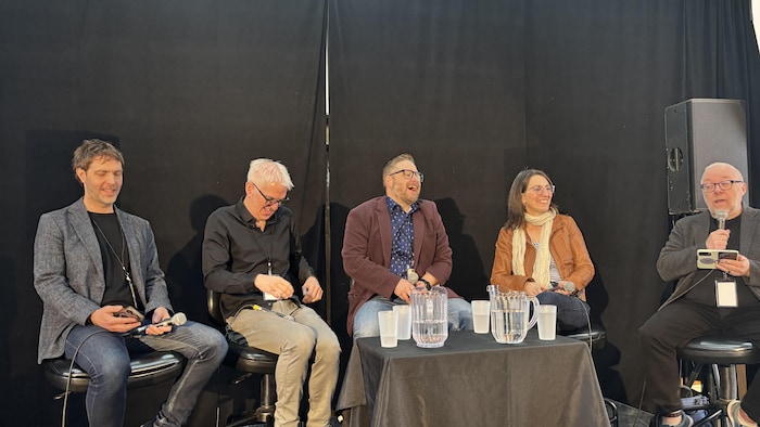 Des participants à un panel qui rigolent.