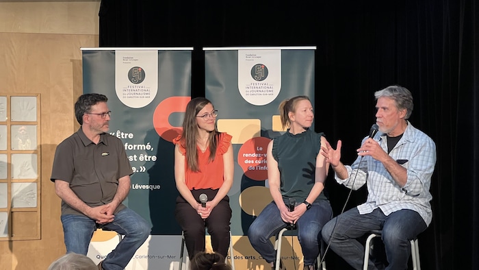 Les journalistes Jean-François Deschênes, Isabelle Larose, l'animatrice Caroline Farley et le journaliste Gilles Gagné en avant sur une tribune.