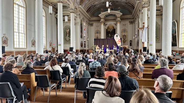 Des festivaliers qui écoutent une conférence.