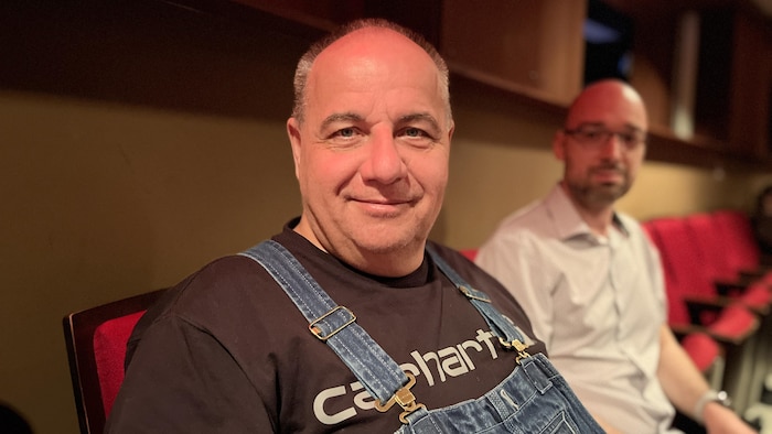 Jean-François Deault regarde la caméra en souriant, vêtu d'une salopette.